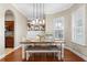 Dining room with modern lighting fixture, shiplap shelving, and an archway leading to the kitchen at 150 Berkley Knights Dr, Auburndale, FL 33823