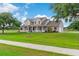 Lovely two-story home with a sprawling green lawn, mature trees, and side-entry garage at 150 Berkley Knights Dr, Auburndale, FL 33823