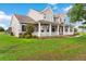 Spacious home with a wide front porch, lush green lawn, and mature landscaping at 150 Berkley Knights Dr, Auburndale, FL 33823