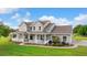 Charming two-story home with a welcoming wrap-around porch and meticulously manicured lawn at 150 Berkley Knights Dr, Auburndale, FL 33823