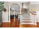 Elegant foyer with hardwood floors, staircase, and open view into the living room at 150 Berkley Knights Dr, Auburndale, FL 33823