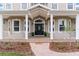 Inviting front porch with classic columns, decorative front door, and manicured landscaping at 150 Berkley Knights Dr, Auburndale, FL 33823