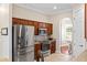 Kitchen featuring stainless steel appliances, wood cabinets, and an open archway leading to the dining area at 150 Berkley Knights Dr, Auburndale, FL 33823