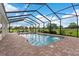 Enjoy a screened-in pool and brick patio with views of a lush, expansive yard at 150 Berkley Knights Dr, Auburndale, FL 33823