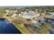 Beautiful aerial view of the community center with tennis courts, a pond with a dock, and manicured green spaces at 1506 Longbow Dr, Lakeland, FL 33810