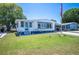 Charming single-story home with blue and white trim, lush lawn, and an American flag at 1506 Longbow Dr, Lakeland, FL 33810