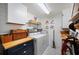 Bright laundry room features a washer, dryer, storage cabinets, butcher block countertop, and shiplap walls at 1506 Longbow Dr, Lakeland, FL 33810