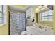 Bathroom with a classic white sink, patterned shower curtain, and a window for natural light at 170 Browning Cir, Winter Haven, FL 33884