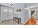 Inviting home foyer with tile floors, bench seating and a decorative light fixture at 170 Browning Cir, Winter Haven, FL 33884