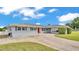 Charming single-story home featuring a red front door, large driveway and covered parking at 170 Browning Cir, Winter Haven, FL 33884