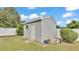 An outdoor shed with a white door is surrounded by greenery and vibrant plants at 170 Browning Cir, Winter Haven, FL 33884