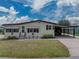 Well-kept single-story home with a covered parking area and manicured lawn under a partly cloudy sky at 1823 Sherwood Hill Dr, Lakeland, FL 33810