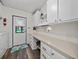 Bright laundry room featuring washer and dryer, storage cabinets, and access to the outside at 1823 Sherwood Hill Dr, Lakeland, FL 33810