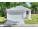 The exterior of a one-story home shows the gray roof, white paint, two-car garage, and green lawn at 1850 Martin Luther King, Jr. E Blvd, Bartow, FL 33830