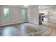 Bright living room features hardwood-style floors, two windows, and white cabinets and stainless appliances in the adjoining kitchen at 1850 Martin Luther King, Jr. E Blvd, Bartow, FL 33830
