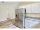Bright kitchen features stainless steel refrigerator, white cabinets, and gray granite countertops at 1890 Martin Luther King, Jr. E Blvd, Bartow, FL 33830