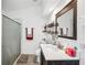 Well-lit bathroom with a glass shower, vanity, decorative shelving, and a large mirror at 217 Dillon Way, Davenport, FL 33897
