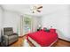 Cozy bedroom with hardwood floors, ceiling fan, and a reading chair at 217 Dillon Way, Davenport, FL 33897