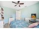Comfortable bedroom with ceiling fan, blue bedding, and bright white desk and shelving at 217 Dillon Way, Davenport, FL 33897