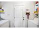 Bright laundry room featuring white washer, dryer, utility sink, and additional storage shelves at 217 Dillon Way, Davenport, FL 33897