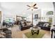 Open-concept living room with tile floors, a ceiling fan, and an open view to the kitchen at 217 Dillon Way, Davenport, FL 33897