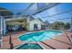 Backyard screened-in pool with a connecting hot tub and deck area with patio furniture at 217 Dillon Way, Davenport, FL 33897