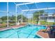 Screened-in pool and spa with patio seating, perfect for outdoor relaxation and entertaining at 217 Dillon Way, Davenport, FL 33897
