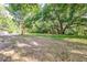 The backyard features a lush green lawn and mature trees providing ample shade at 2400 Avenue D Sw, Winter Haven, FL 33880
