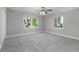 This bedroom features gray carpet and two large windows with a lovely green outdoor view at 2400 Avenue D Sw, Winter Haven, FL 33880