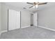 This bedroom features gray carpet, a ceiling fan, and a built in closet at 2400 Avenue D Sw, Winter Haven, FL 33880