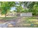 Charming one-story home nestled among mature trees, boasting a modern facade and a well-maintained front yard at 2400 Avenue D Sw, Winter Haven, FL 33880