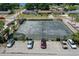Aerial view of an outdoor community tennis court with a parking lot featuring multiple vehicles nearby at 2500 21St Nw St # 78, Winter Haven, FL 33881