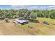Aerial view of the home surrounded by green lawns, trees and an outdoor firepit with a boat in the backyard at 3728 Old Polk City Rd, Lakeland, FL 33809