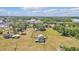 Aerial view showing a single-Gathering home surrounded by large fields, trees, and nearby commercial buildings at 3728 Old Polk City Rd, Lakeland, FL 33809
