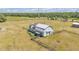 Aerial shot of a barn with a damaged roof, surrounded by grassy fields and fence at 3728 Old Polk City Rd, Lakeland, FL 33809