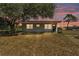 Charming single-story home at dusk with a well-maintained lawn and mature landscaping at 3728 Old Polk City Rd, Lakeland, FL 33809