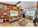 Cozy living room featuring a comfortable sofa, wood-paneled walls, and curated decor; bright natural light at 3728 Old Polk City Rd, Lakeland, FL 33809