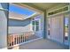Close-up of the covered front porch, showcasing the white railing and beautifully landscaped garden at 4027 Tullamore Ln, Auburndale, FL 33823