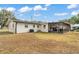 Wide view of the backyard with a screened-in patio attached to the white brick house at 435 Lyle Pkwy, Bartow, FL 33830