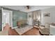 Bedroom features a wooden crib, accent wall, and a cozy armchair, creating a warm and inviting space at 435 Lyle Pkwy, Bartow, FL 33830
