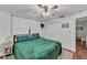 Bedroom with ceiling fan features green bedspread, window, side tables, and a walk in closet at 435 Lyle Pkwy, Bartow, FL 33830