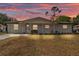 Charming white brick home with a cozy front porch and well-maintained lawn at dusk at 435 Lyle Pkwy, Bartow, FL 33830
