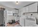 Bright laundry room features modern washer and dryer, storage cabinets, and a window for natural light at 435 Lyle Pkwy, Bartow, FL 33830