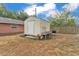 Backyard storage shed and grill next to a wooden fence and residential area at 435 Lyle Pkwy, Bartow, FL 33830