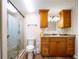 Bathroom featuring wood cabinets, a shower with glass doors, and updated fixtures at 4830 Melody Ln, Lakeland, FL 33805