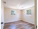 Bright bedroom showcasing wood flooring, two windows, neutral walls, and a ceiling fan at 4830 Melody Ln, Lakeland, FL 33805