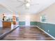 Bright living room featuring wood flooring, a ceiling fan, and an open floor plan leading to the kitchen at 4830 Melody Ln, Lakeland, FL 33805