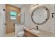 Modern bathroom with natural stone wall, framed mirror, and glass shower at 5087 Cliffside Drive, Lakeland, FL 33813