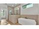 Modern bathroom featuring glass shower and soaking tub with accent wall at 5087 Cliffside Drive, Lakeland, FL 33813