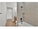 Modern bathroom featuring a tiled shower-tub combo with neutral tile and updated fixtures and vanity at 5087 Cliffside Drive, Lakeland, FL 33813